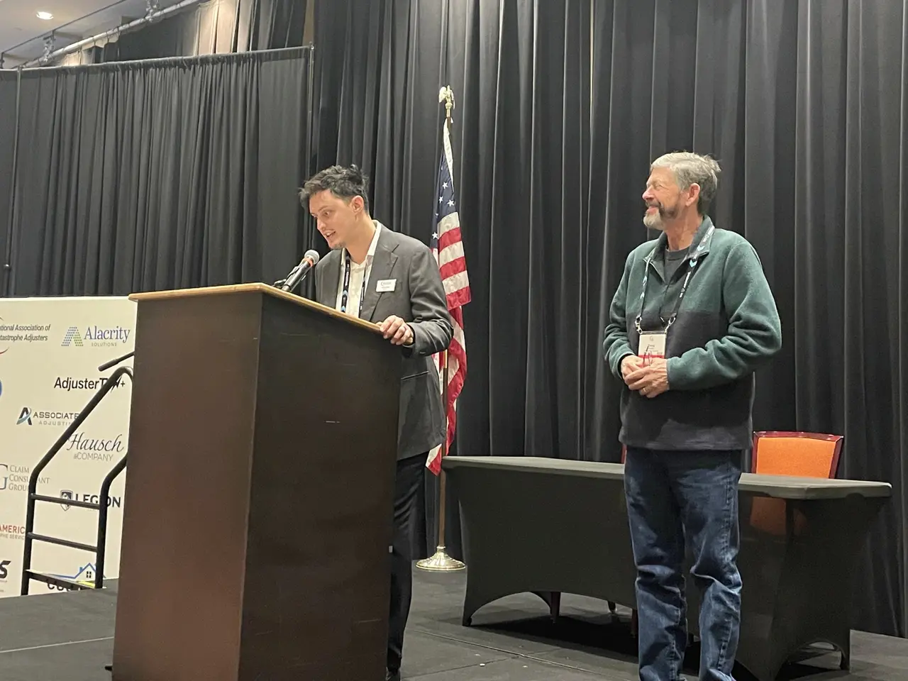 Julian Badillo speaking at a podium at the 2026 NACA Convention in Durant, Oklahoma